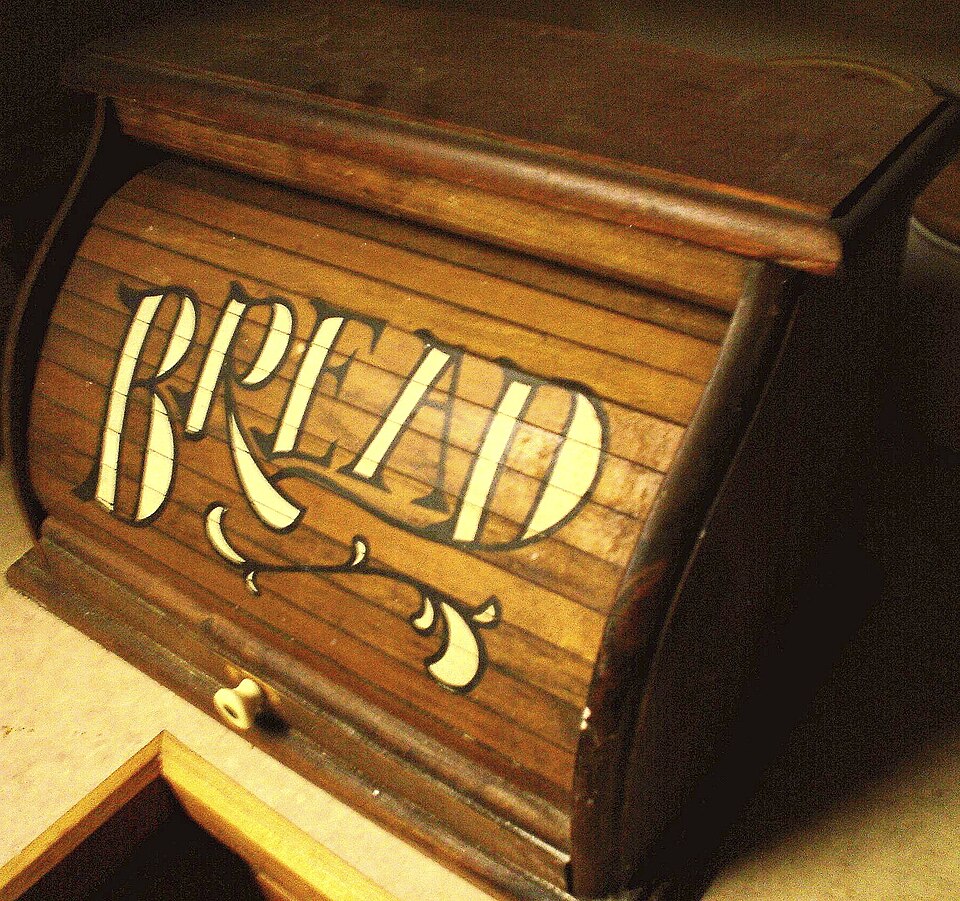 A wooden roll-top bread bin