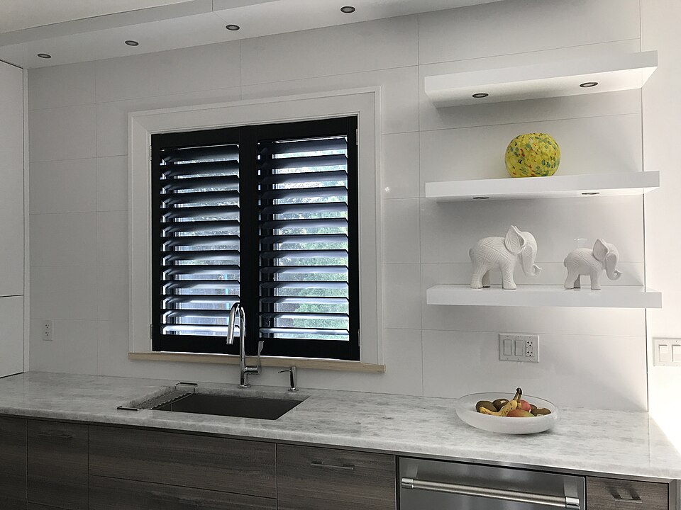 Dark shutters fitted to a window above a kitchen sink