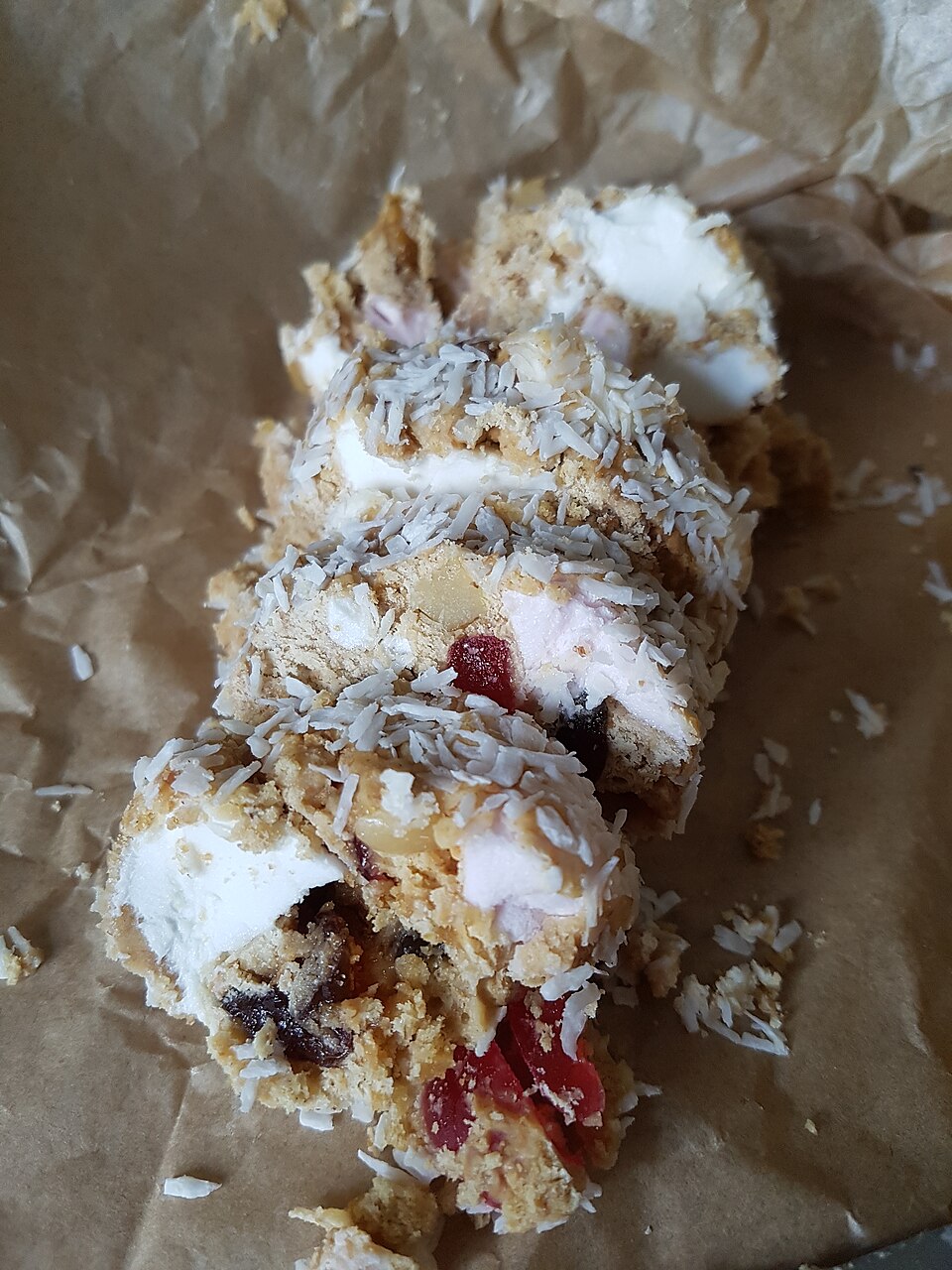 Slices of fifteens with marshmallows and cherries, rolled in coconut