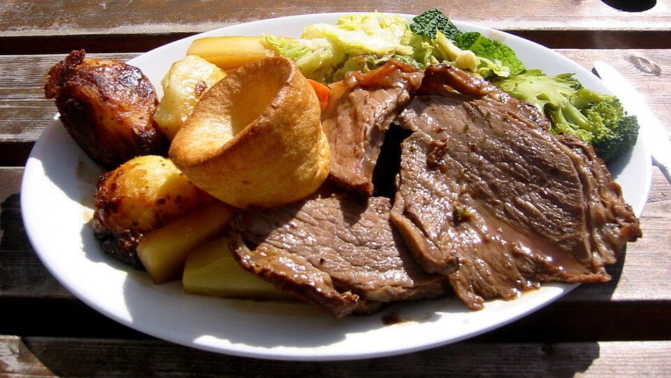Sliced roast beef with Yorkshire puddings, roast potatoes and gravy