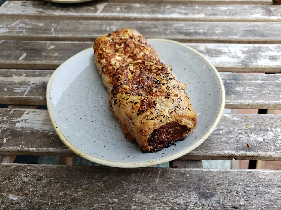 A golden pork sausage roll on a plate