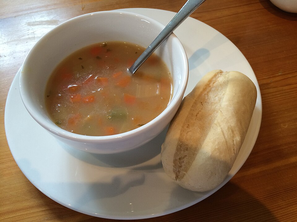 A bowl of Scotch broth served with a bread roll