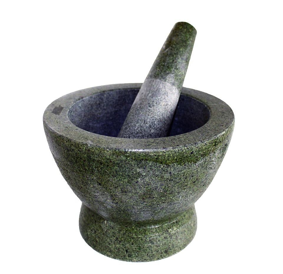A heavy green stone pestle and mortar
