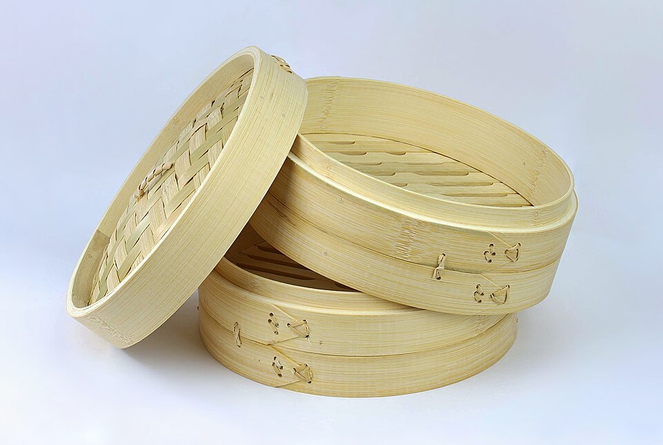 A two-tier bamboo steamer with its lid