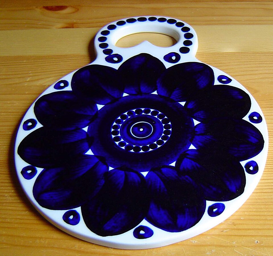A round ceramic trivet with a blue pattern